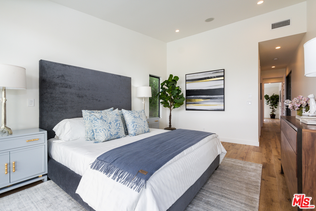 2084 Roscomare Road Los Angeles, CA 90077 - Photo 12 of 22 a bedroom with a bed and a potted plant on dresser
