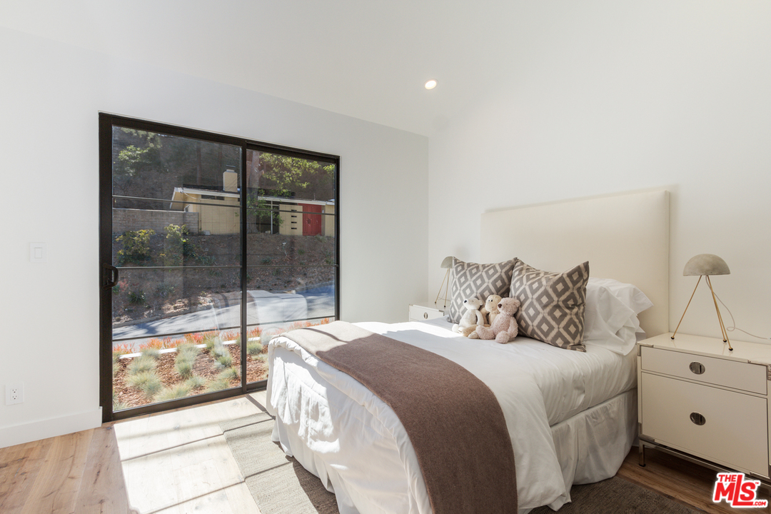 2084 Roscomare Road Los Angeles, CA 90077 - Photo 17 of 22 a bedroom with a large bed and a large window