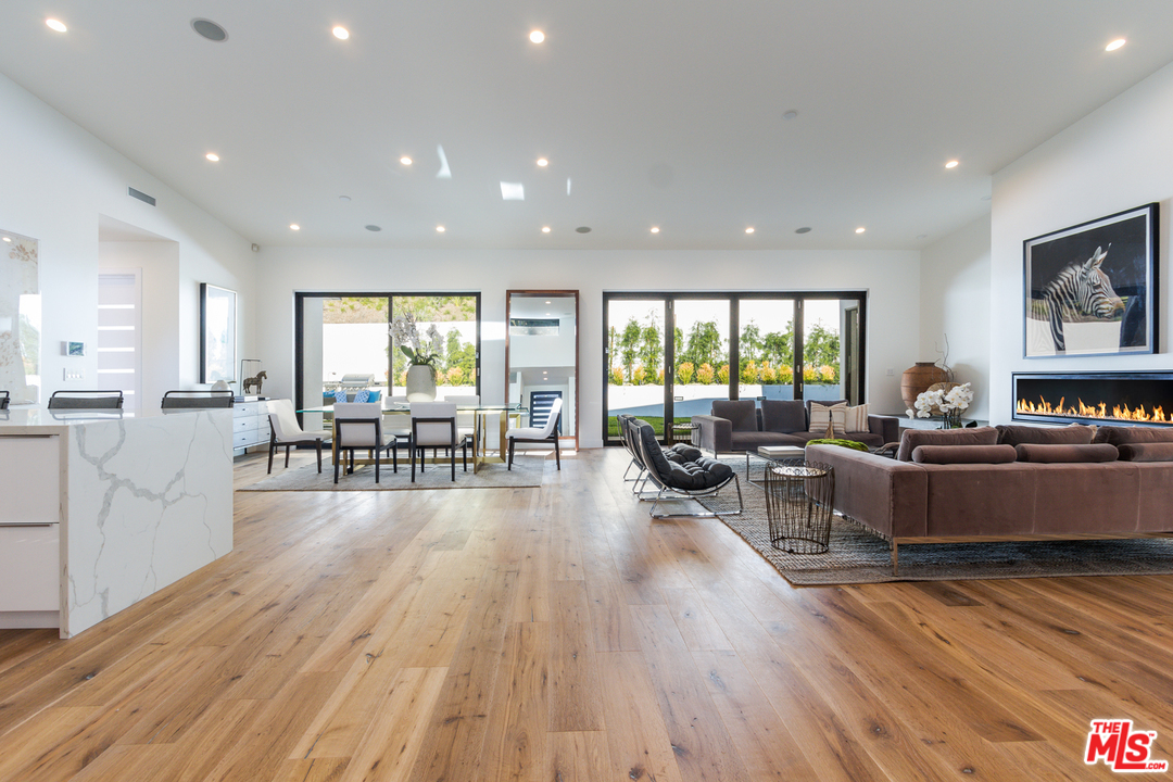 2084 Roscomare Road Los Angeles, CA 90077 - Photo 4 of 22 a large living room with stainless steel appliances wooden floor a large window and way to kitchen