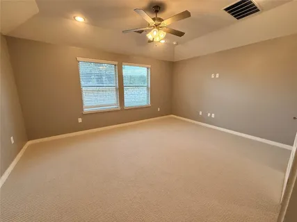 an empty room with windows and fan