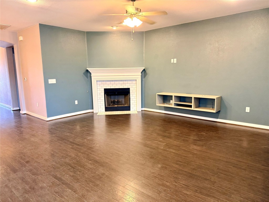 7216 Sienna Rouge Path Austin, TX 78744 - Photo 7 of 37 an empty room with wooden floor fire place and windows