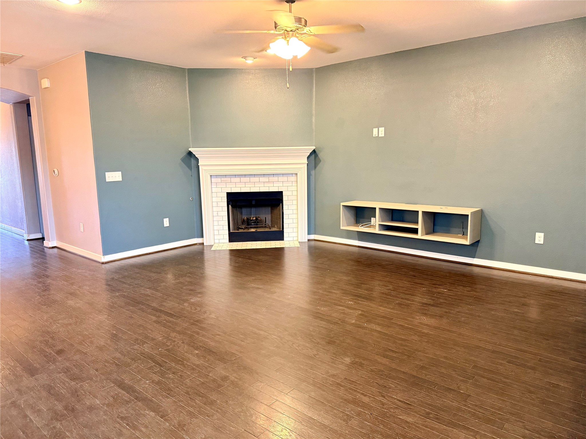7216 Sienna Rouge Path Austin, TX 78744 - Photo 7 of 37 an empty room with wooden floor fire place and windows
