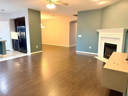 a view of a livingroom with wooden floor and a fireplace