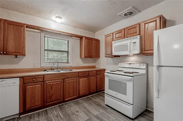 a kitchen with stainless steel appliances granite countertop a stove a sink dishwasher and a refrigerator