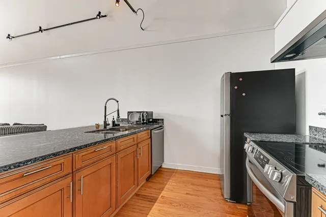 a kitchen with stainless steel appliances granite countertop a sink and a stove