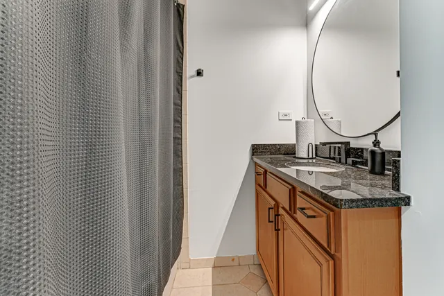 a bathroom with a granite countertop sink and a mirror