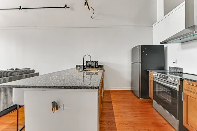 a kitchen with granite countertop a refrigerator and a sink