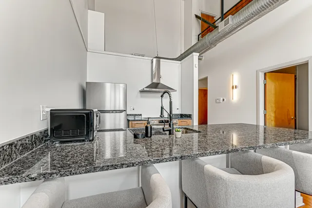 a kitchen with stainless steel appliances granite countertop a sink and a counter space