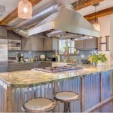 a kitchen with stainless steel appliances granite countertop a sink a stove and refrigerator