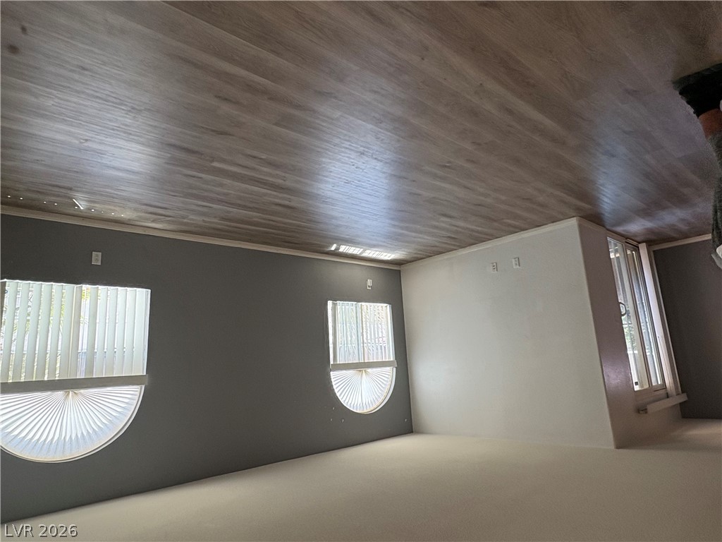 9325 West Desert Inn Road, Unit 123 Las Vegas, NV 89117 - Photo 6 of 36 Natural light streams into this versatile living area, highlighting the planked ceiling and cozy carpeting.