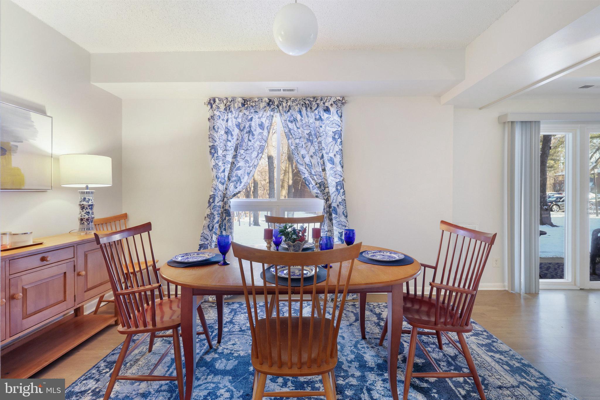 11812 Breton Court, Unit 1A Reston, VA 20191 - Photo 13 of 47 a view of a dining room with furniture wooden floor and a chandelier