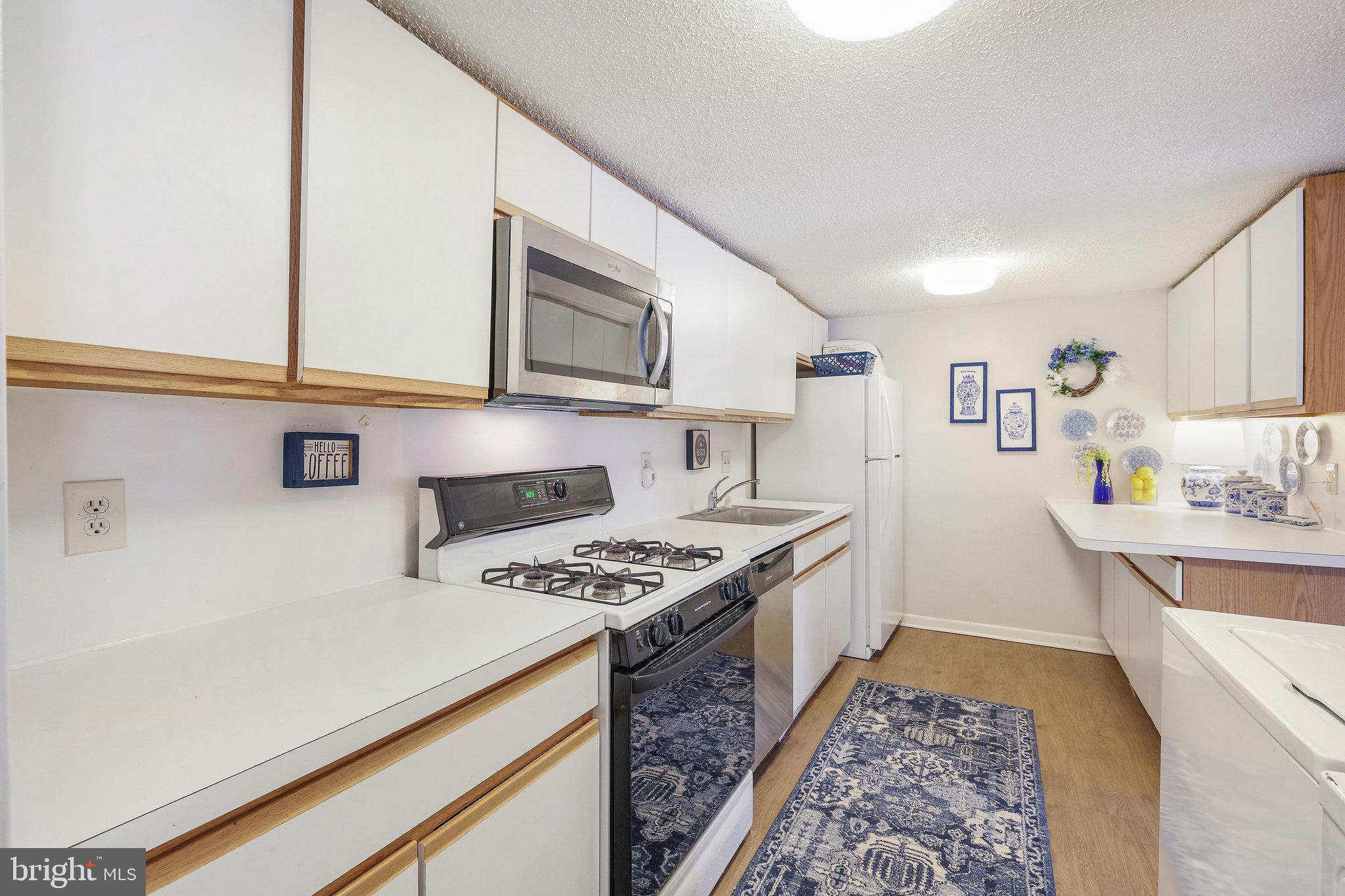 11812 Breton Court, Unit 1A Reston, VA 20191 - Photo 16 of 47 a kitchen with stainless steel appliances granite countertop a stove and a microwave