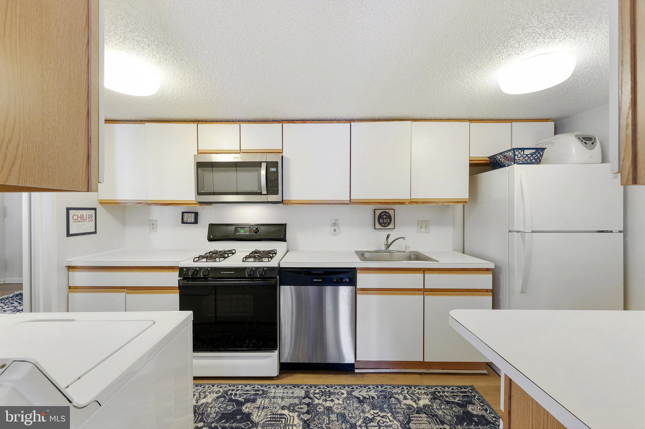 11812 Breton Court, Unit 1A Reston, VA 20191 - Photo 18 of 47 a kitchen with stainless steel appliances a stove a sink and a refrigerator