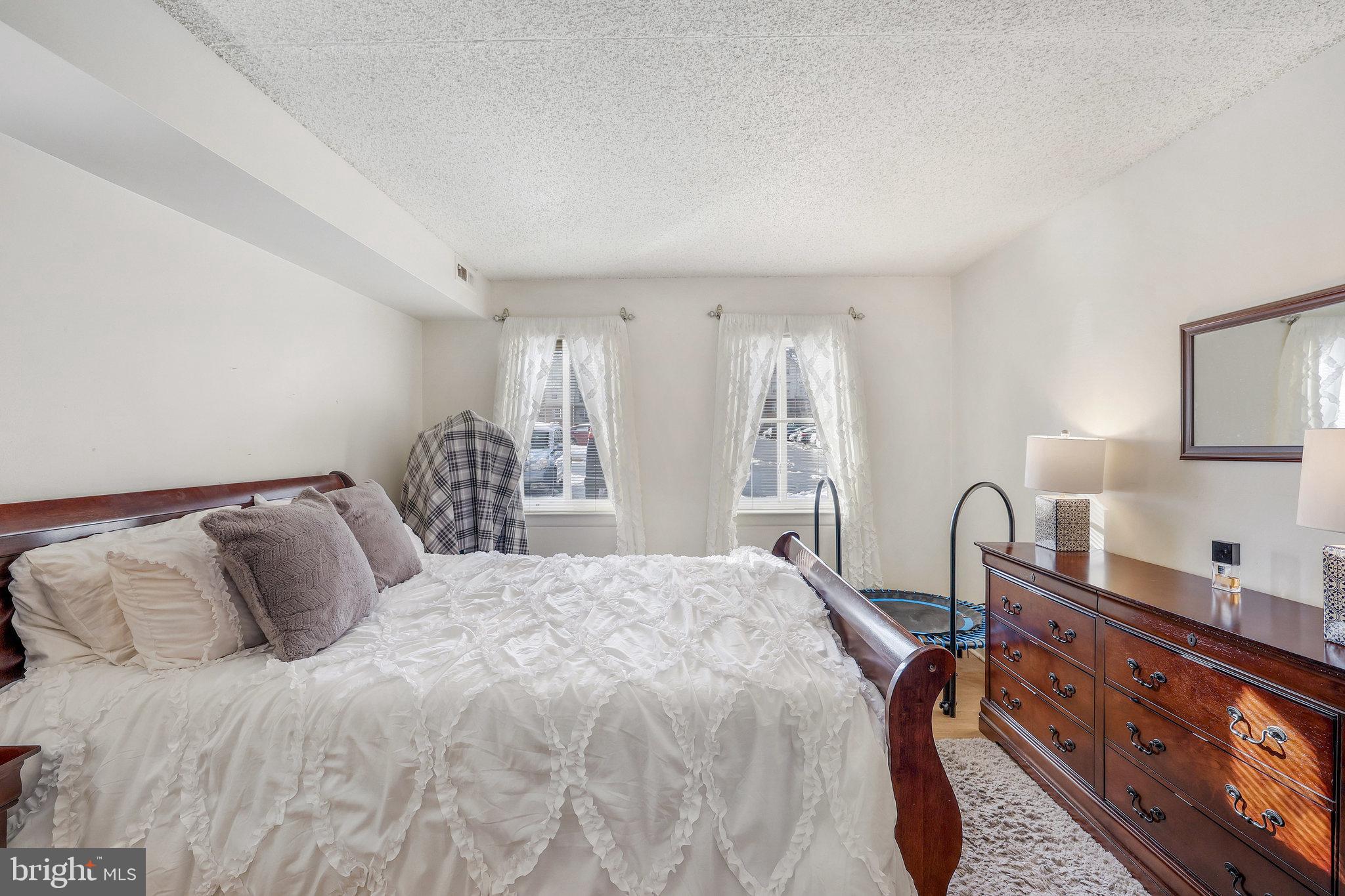 11812 Breton Court, Unit 1A Reston, VA 20191 - Photo 21 of 47 a bedroom with a bed a dresser and next to a window