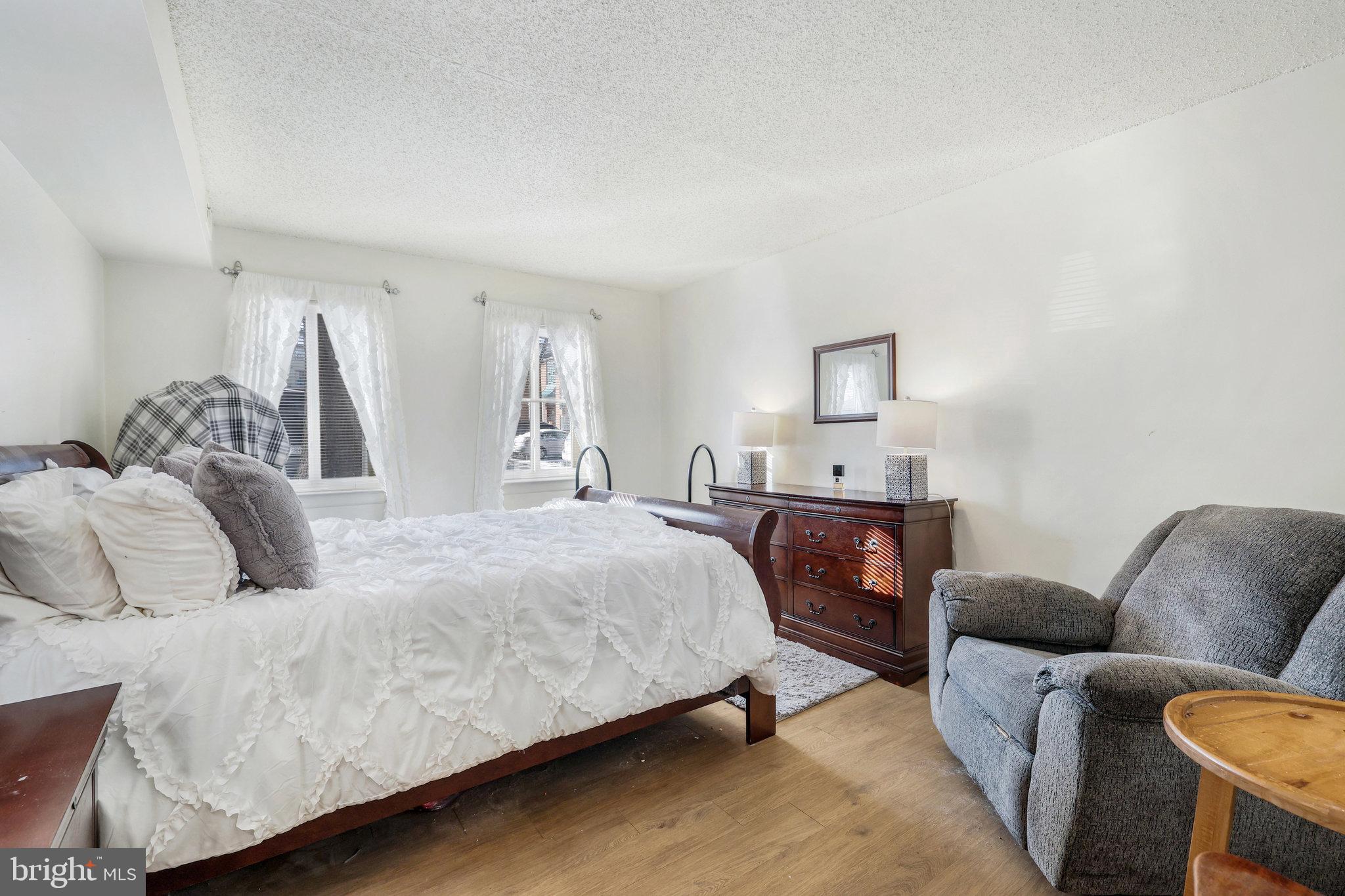 11812 Breton Court, Unit 1A Reston, VA 20191 - Photo 22 of 47 a bedroom with a bed couch and a window