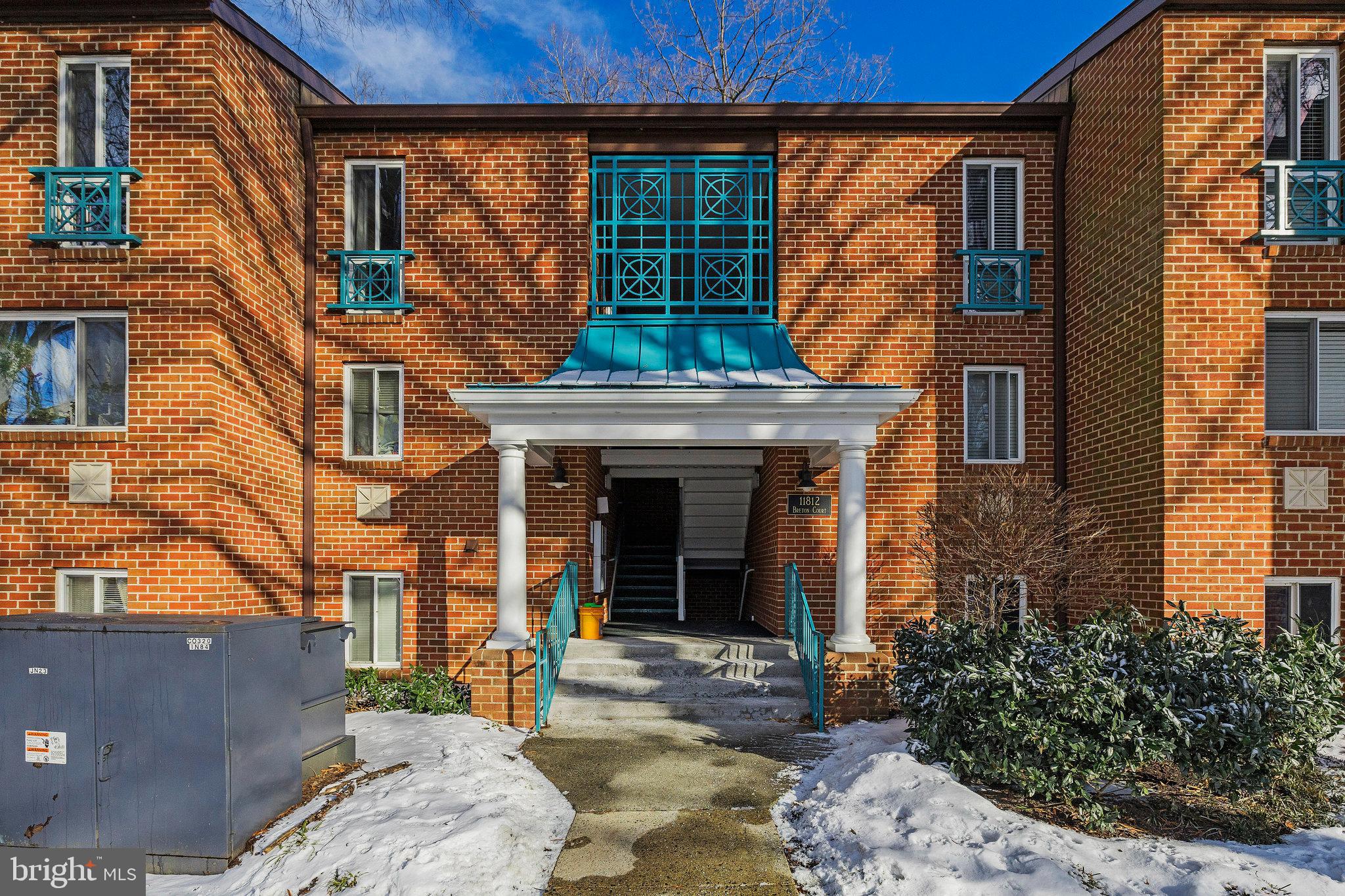 11812 Breton Court, Unit 1A Reston, VA 20191 - Photo 34 of 47 a view of a brick house with plants and large tree