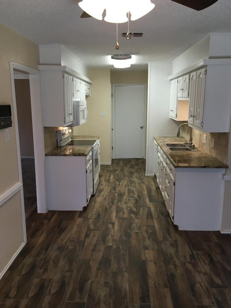 5739 Emory Street Lubbock, TX 79416 - Photo 6 of 10 a kitchen with granite countertop a sink and stove