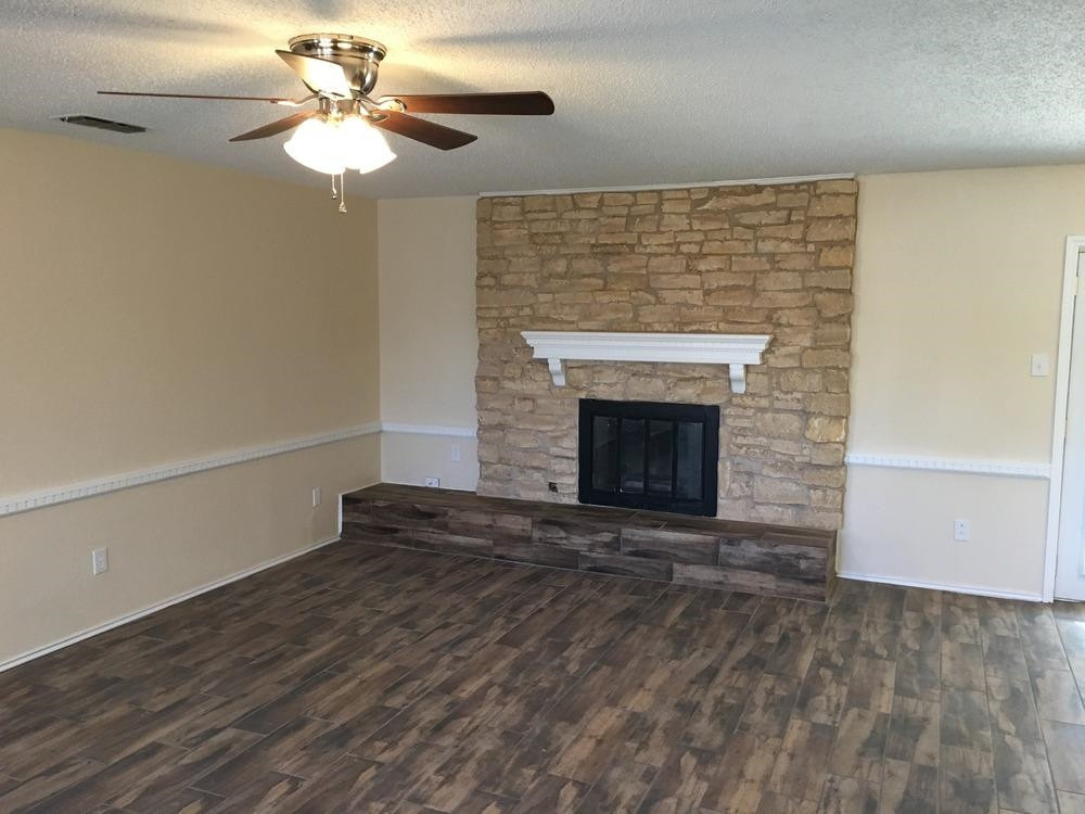 5739 Emory Street Lubbock, TX 79416 - Photo 8 of 10 a view of an empty room with a fireplace