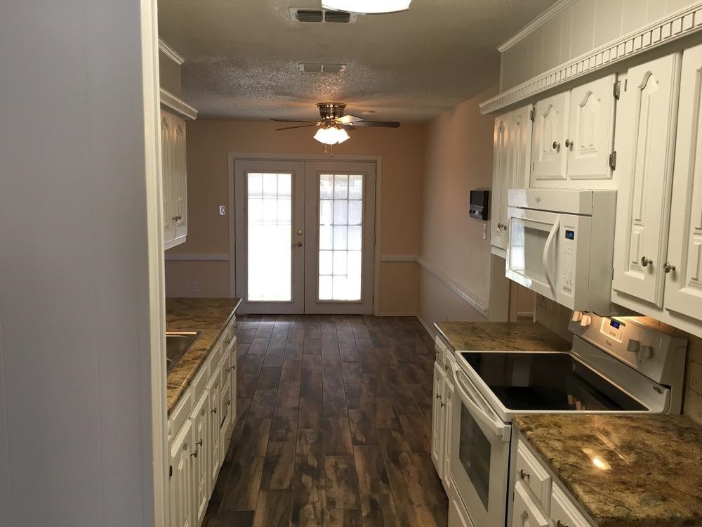 5739 Emory Street Lubbock, TX 79416 - Photo 9 of 10 a kitchen that has a sink cabinets and a stove