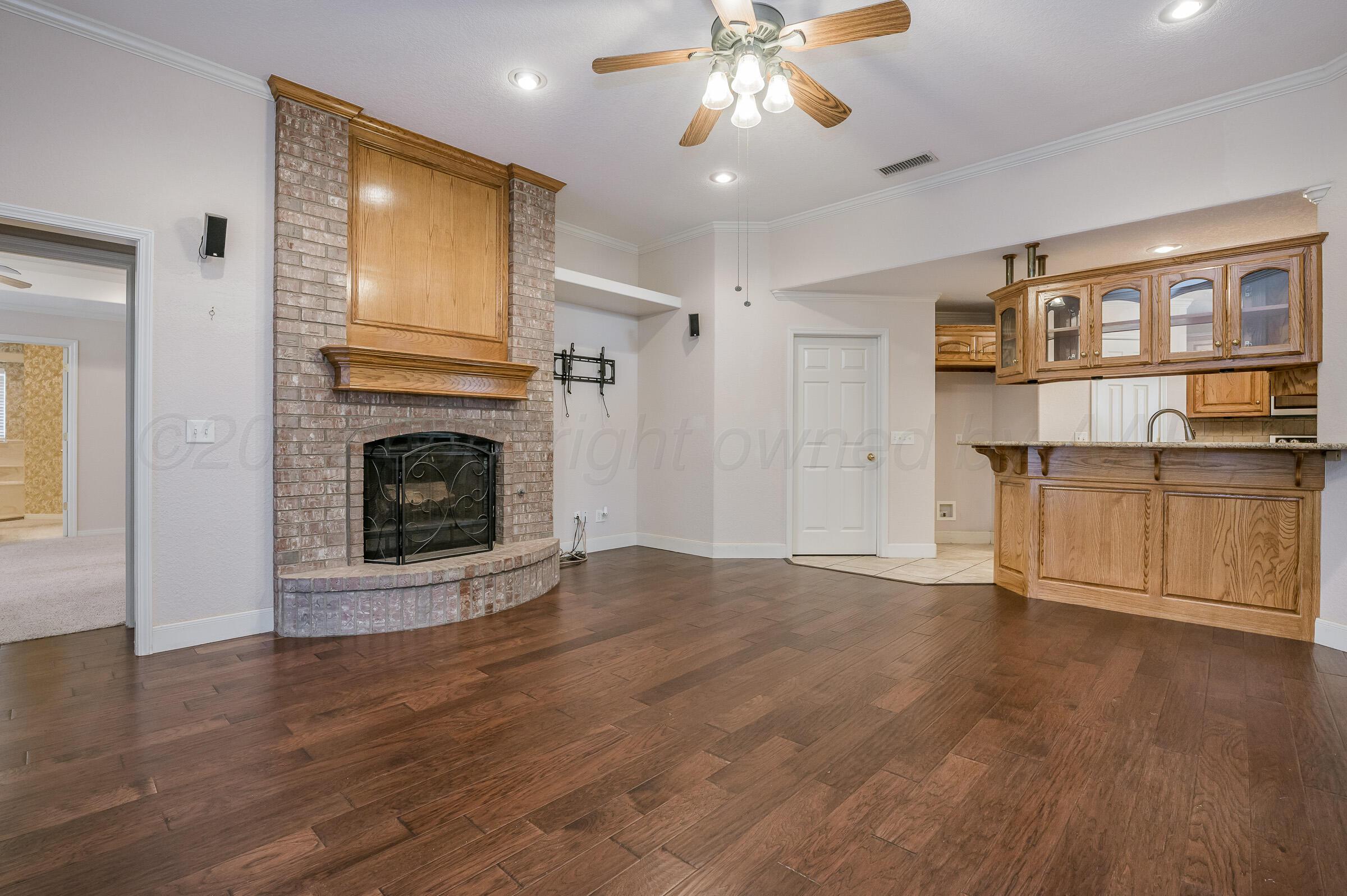6308 Academy Drive Amarillo, TX 79119 - Photo 6 of 21 a view of a livingroom with a fireplace a ceiling fan and windows