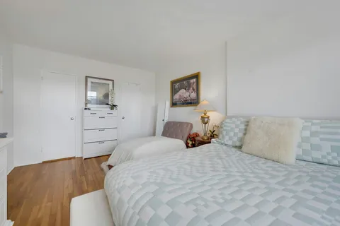 a bedroom with a bed and painting on the wall