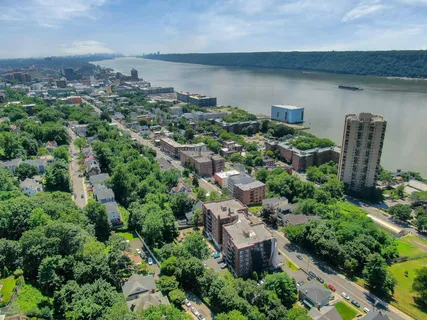 an aerial view of residential house with outdoor space and trees all around