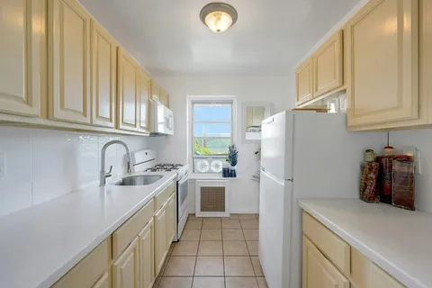 a kitchen with a sink a refrigerator and cabinets