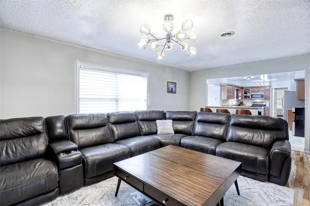 a living room with furniture a chandelier and a window