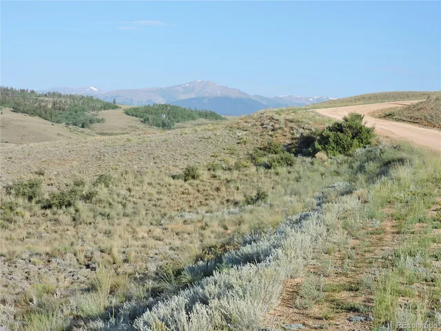 a view of a dry yard with mountains in the background