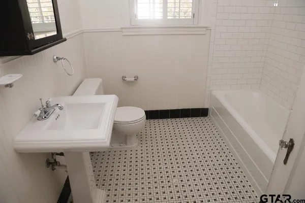 a bathroom with a sink a toilet and window