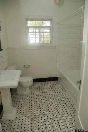 a bathroom with a sink a toilet and a shower