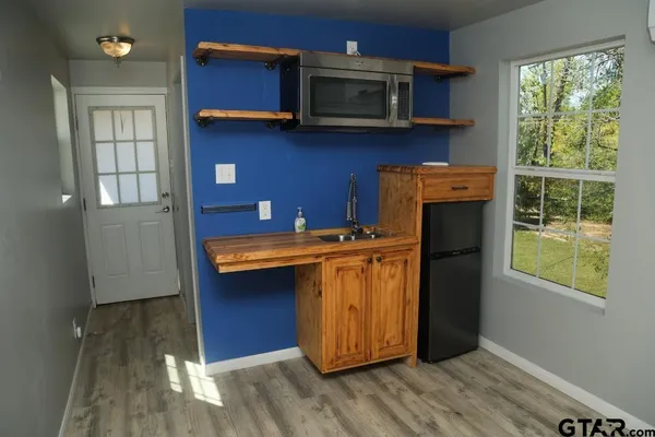 a kitchen with stainless steel appliances granite countertop a refrigerator a sink a stove and wooden floor