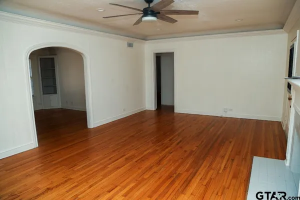 a view of empty room with wooden floor