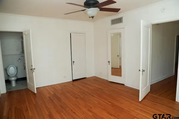 a view of empty room with wooden floor