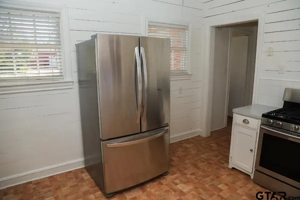 a kitchen with stainless steel appliances granite countertop a refrigerator and a stove