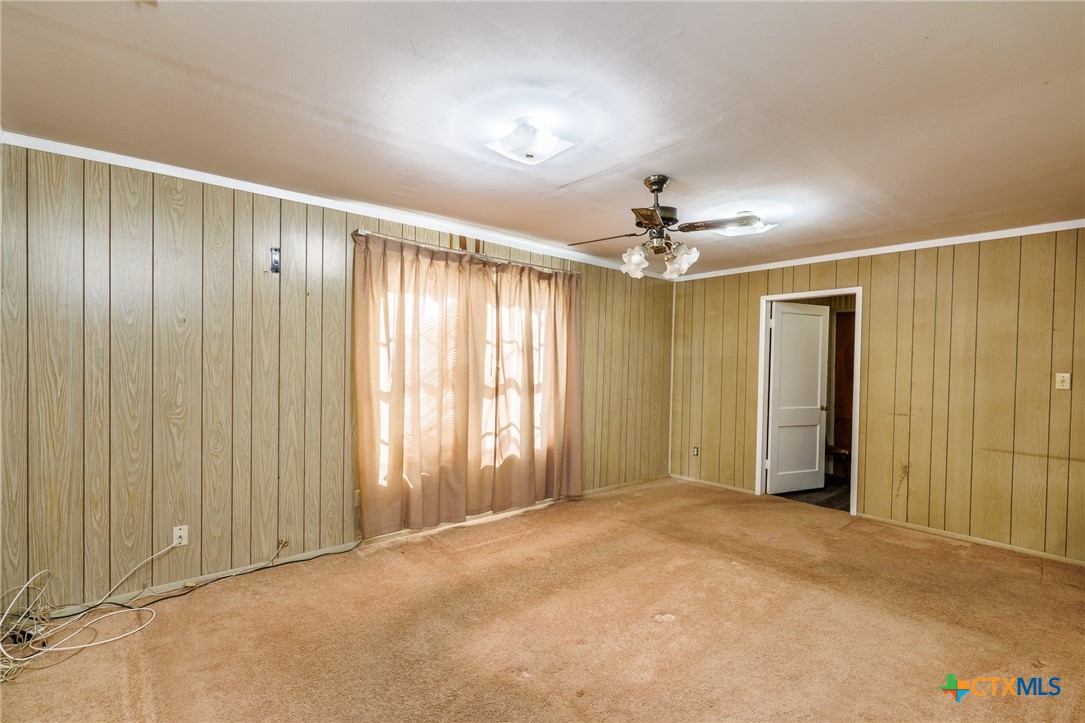 921 Robertson Gonzales, TX 78629 - Photo 11 of 31 an empty room with a ceiling fan and a window