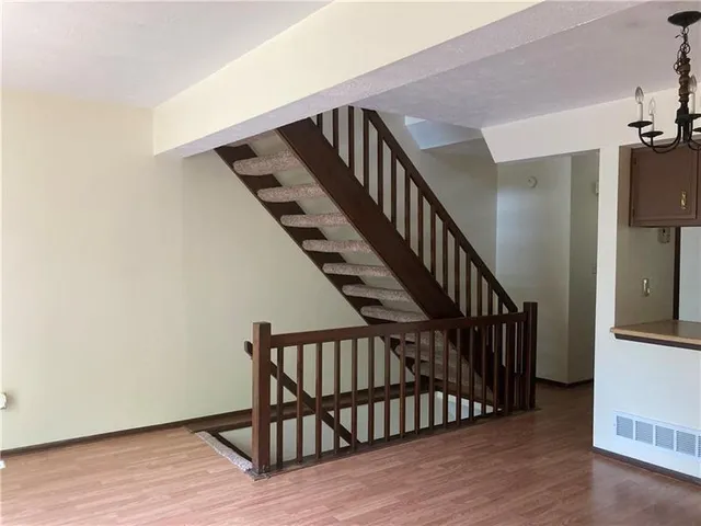 a view of staircase with railing and white walls