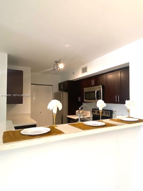 2061 Renaissance Boulevard, Unit 204 Miramar, FL 33025 - Photo 13 of 30 a view of a living room with kitchen countertops and a flat screen tv