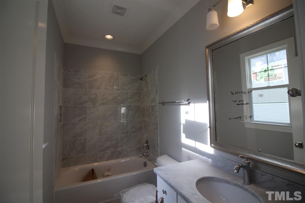 2705 1/2 Gordon Street Raleigh, NC 27608 - Photo 21 of 25 a bathroom with a granite countertop sink a toilet and shower