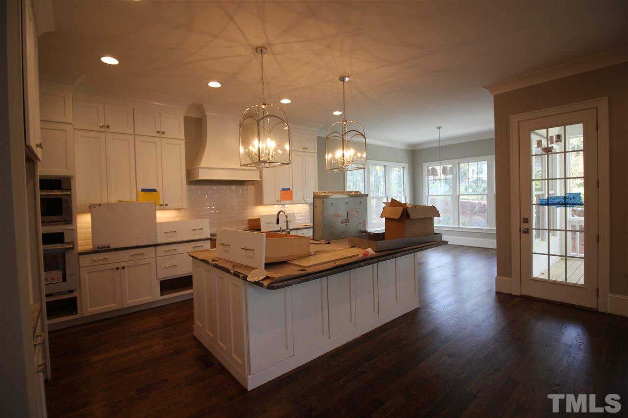 2705 1/2 Gordon Street Raleigh, NC 27608 - Photo 7 of 25 a kitchen with stainless steel appliances granite countertop a sink a stove and a wooden floors