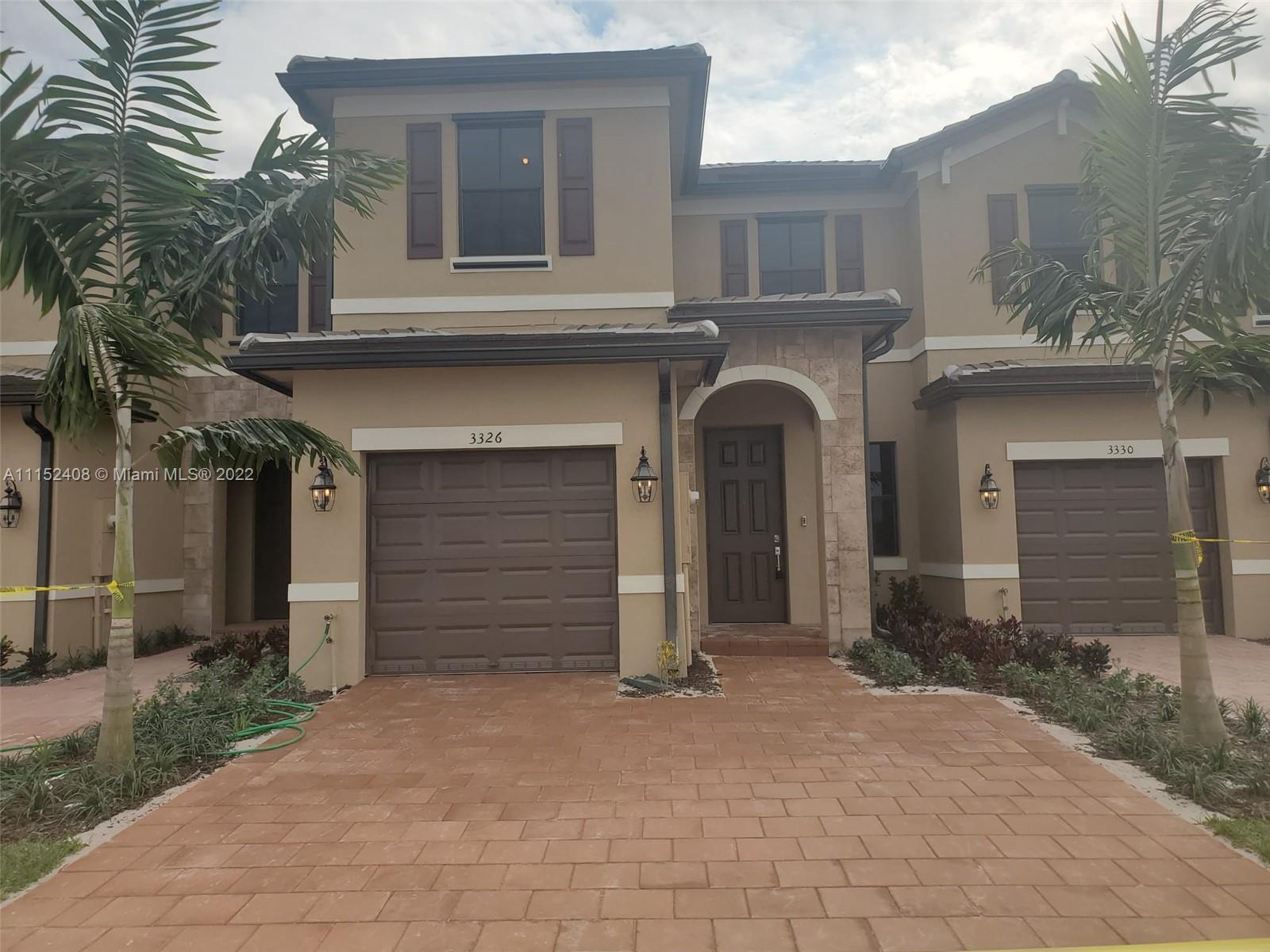 3326 West 112th Street, Unit 3326 Hialeah, FL 33018 - Photo 1 of 25 a front view of a house with a yard