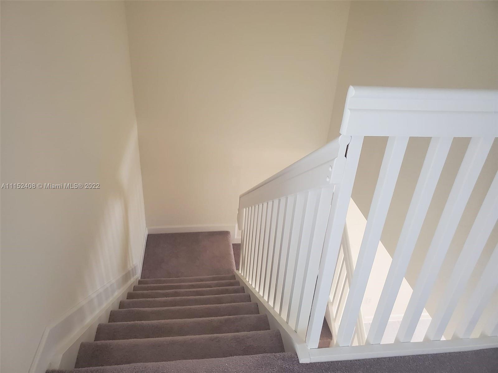 3326 West 112th Street, Unit 3326 Hialeah, FL 33018 - Photo 14 of 25 a view of staircase with railing and white walls