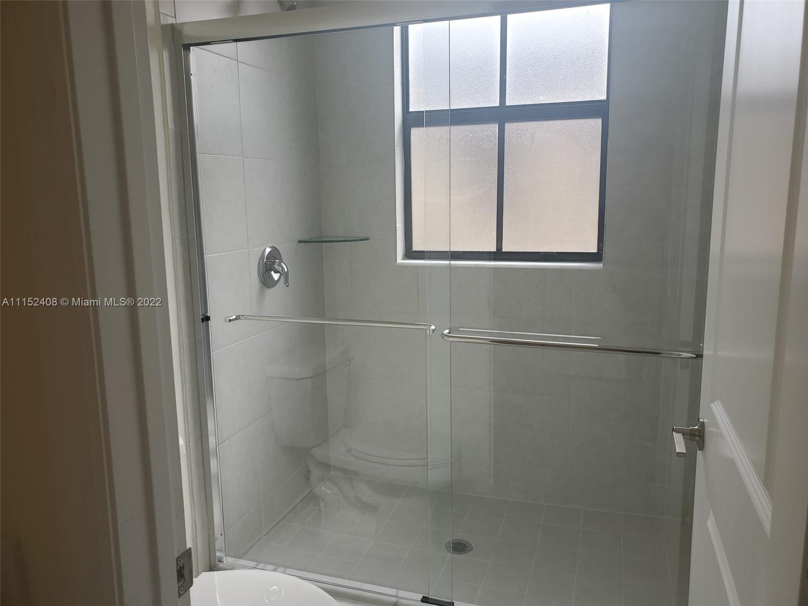 3326 West 112th Street, Unit 3326 Hialeah, FL 33018 - Photo 19 of 25 a bathroom with a glass shower door