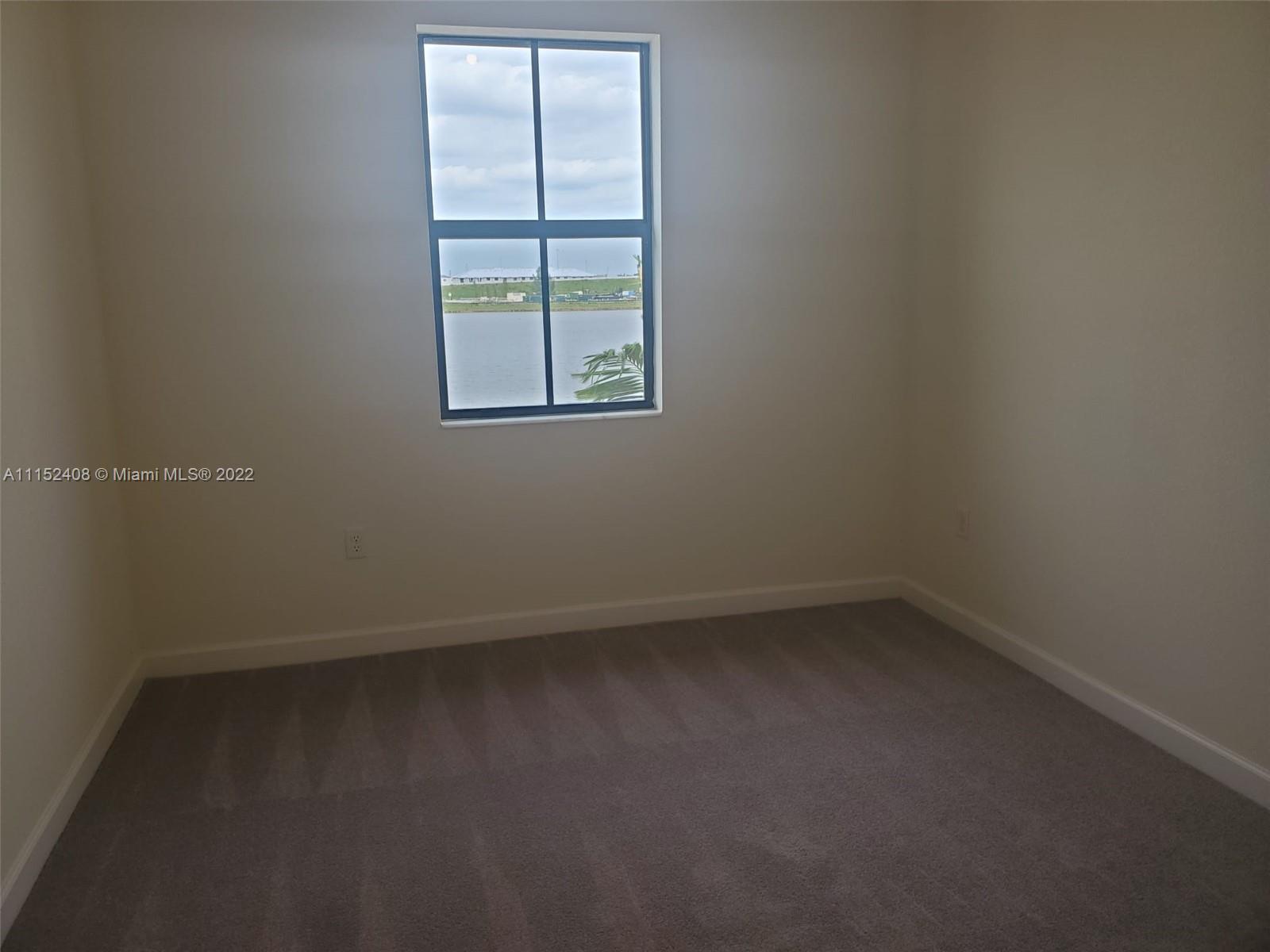 3326 West 112th Street, Unit 3326 Hialeah, FL 33018 - Photo 22 of 25 an empty room with a window