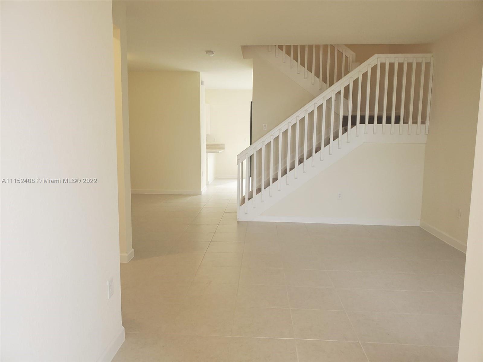 3326 West 112th Street, Unit 3326 Hialeah, FL 33018 - Photo 4 of 25 a view of staircase with railing and white walls