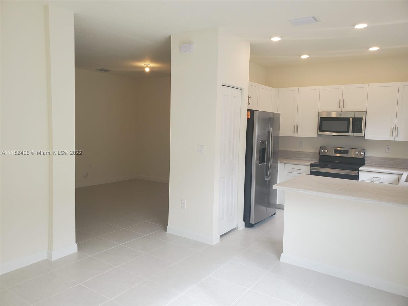 3326 West 112th Street, Unit 3326 Hialeah, FL 33018 - Photo 8 of 25 a kitchen with stainless steel appliances a refrigerator and a stove