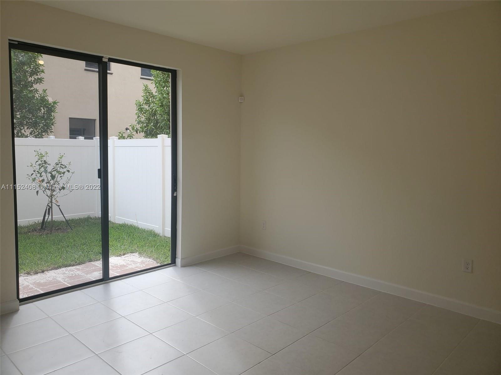 3326 West 112th Street, Unit 3326 Hialeah, FL 33018 - Photo 10 of 25 an empty room with sliding glass door
