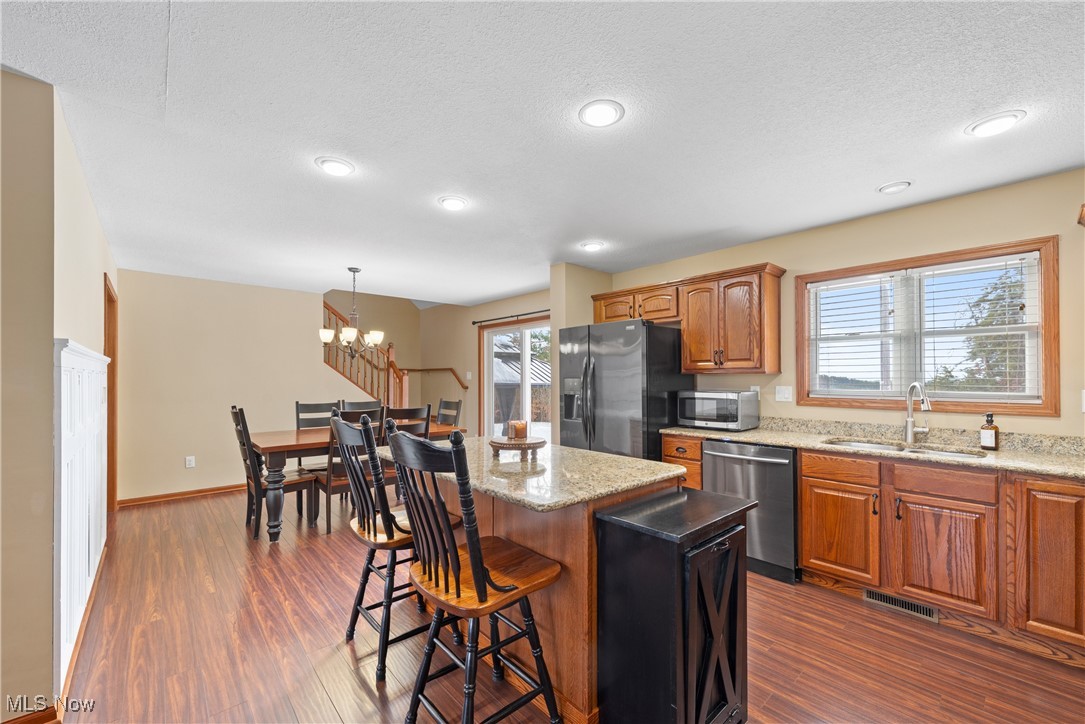 399 Wilder Road Vinton, OH 45686 - Photo 9 of 36 Kitchen with light stone counters, wood finish cabinets, dark wood-style flooring, stainless steel appliances, and a textured ceiling