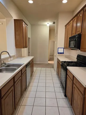 a kitchen with stainless steel appliances a sink stove top oven and cabinets