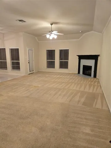 a view of an empty room with window and fireplace